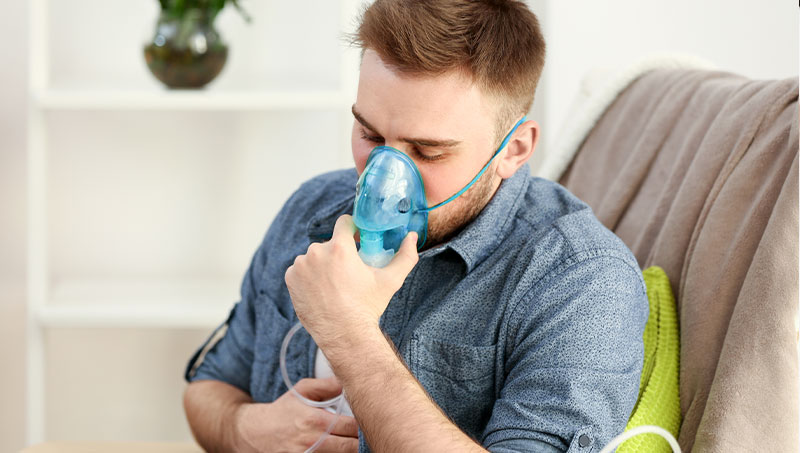 Man with asthma using inhalator