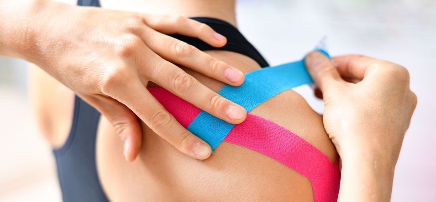 Patient getting kinesion taping on shoulder for muscle pain relief